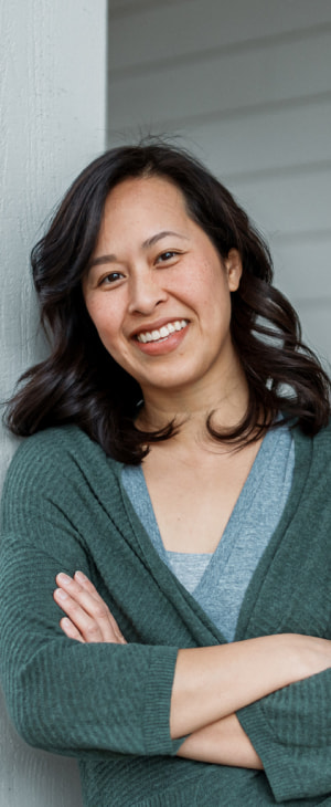 a photo of a person smiling with their arms crossed